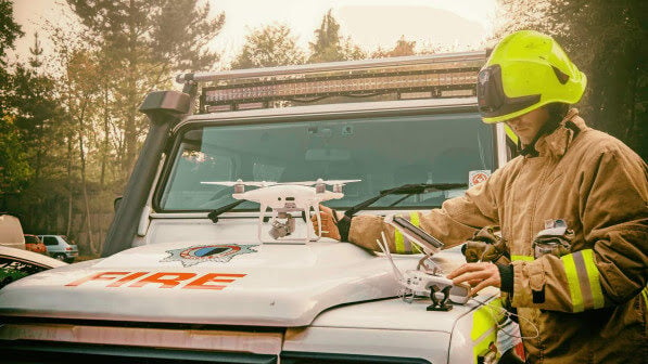 firefighter with drone in front of vehicle