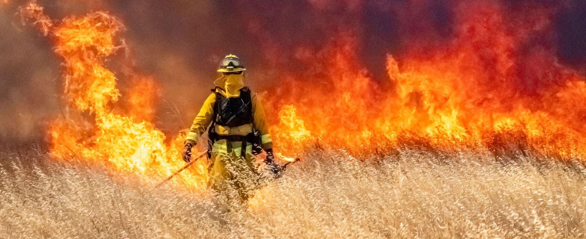 firefighter in front of wildfire